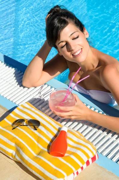Женщина в бассейне расслабляет и пьет — стоковое фото