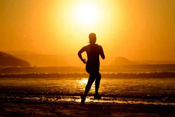 Жінка біжить на красивому заході сонця — стокове фото