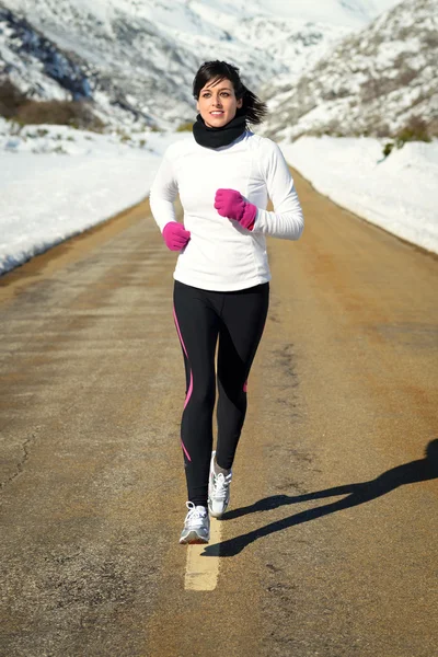 Woman running in winter on road — Stock Photo, Image