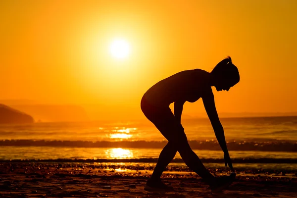 Körperübungen am Strand bei Sonnenuntergang — Stockfoto