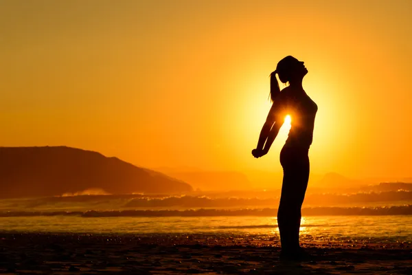 Exercícios relaxantes na praia ao pôr do sol Imagens De Bancos De Imagens