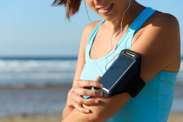 Sportieve vrouw met telefoon sport band — Stockfoto