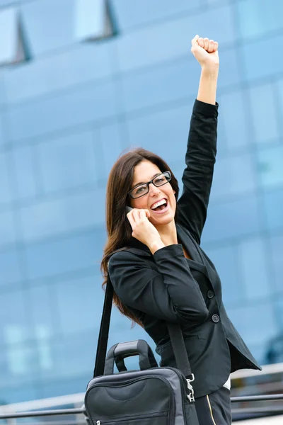 Успешная деловая женщина по телефону поднимает руку — стоковое фото