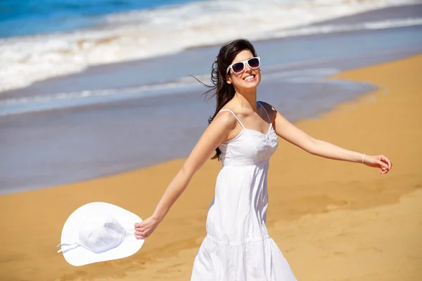 Speelse vrouw wandelen op het strand — Stockfoto