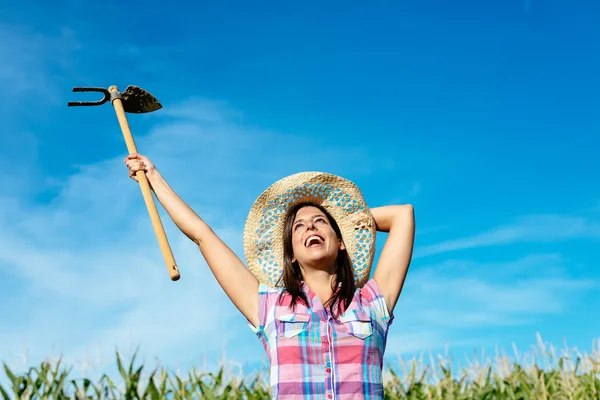 Agricultora bem sucedida levantando enxada — Fotografia de Stock