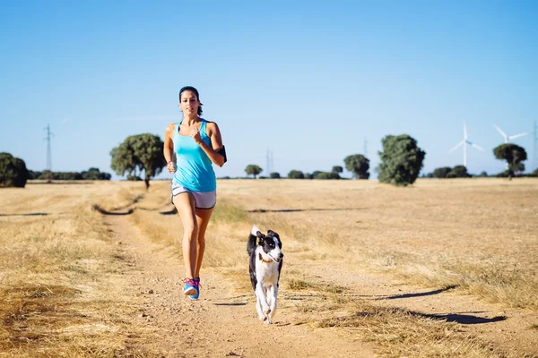 Mujer corriendo sendero cruzado en camino de campo —  Fotos de Stock