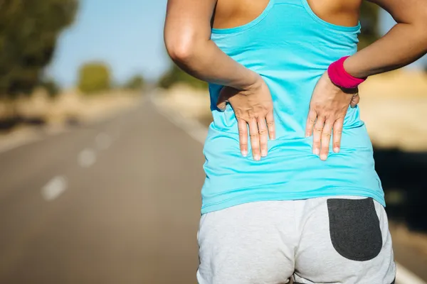 Corredor femenino dolor de espalda — Foto de Stock