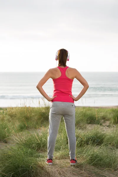 Fitness atleta femenina de pie hacia el mar —  Fotos de Stock