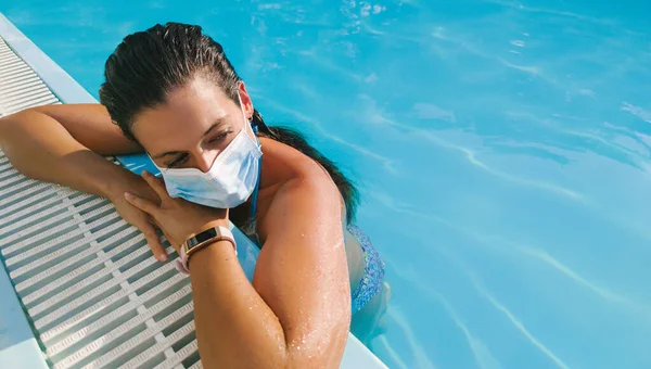 暑假期间 年轻女子带着面具在游泳池迎战Covid — 图库照片