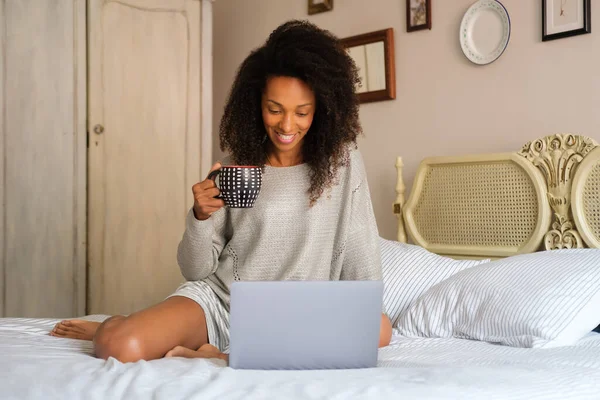 Cheerful Afro Hairstyle Woman Sitting Her Bed Watching Online Content — Stockfoto