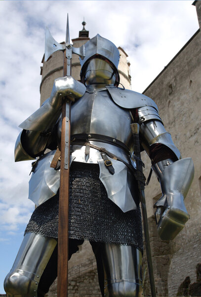Worm's eye view of a knight standing in front of a mediaeval castle