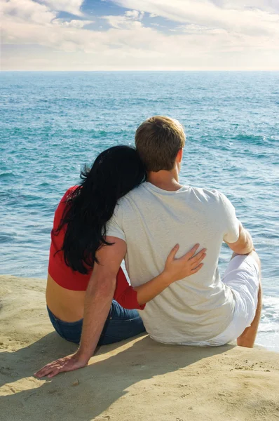 Pareja joven sentada en los acantilados con vistas al Océano Pacífico — Foto de Stock