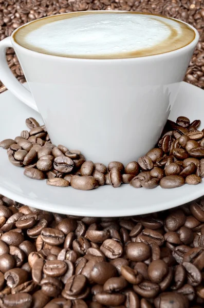 Cappuccino e grãos de café — Fotografia de Stock