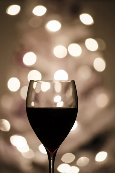 Red wine against blurred lights — Stock Photo, Image