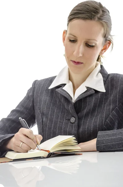 Geschäftsfrau schreibt in ihren Notizblock — Stockfoto