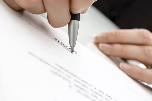 Mão feminina assinando um contrato — Fotografia de Stock