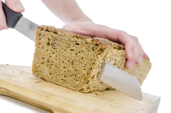 Cutting a homemade bread on a wooden board — Stock Photo, Image