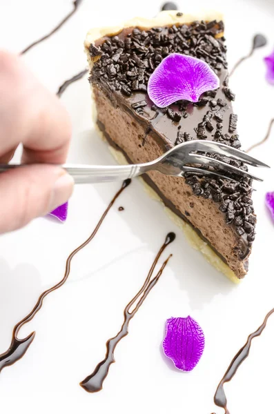 Einen Kuchen essen, der mit rosa Blütenblättern verziert ist — Stockfoto