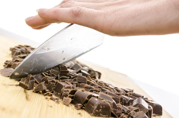 Женская рука режет темный шоколад — стоковое фото