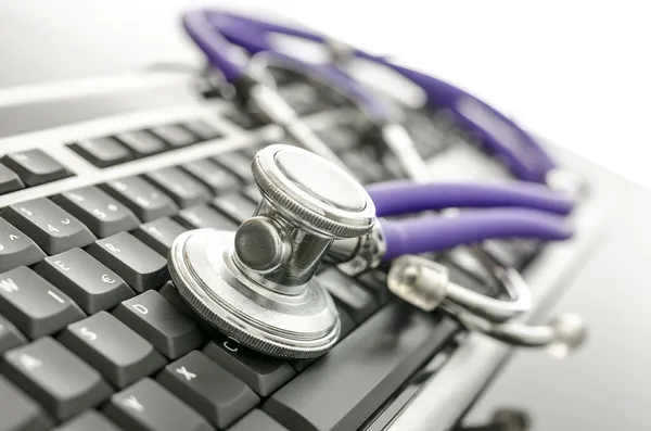 计算机键盘上的医用听诊器 — 图库照片