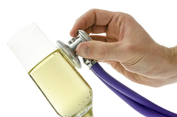 Male hand holding a stethoscope on a glass of wine — Stock Photo, Image