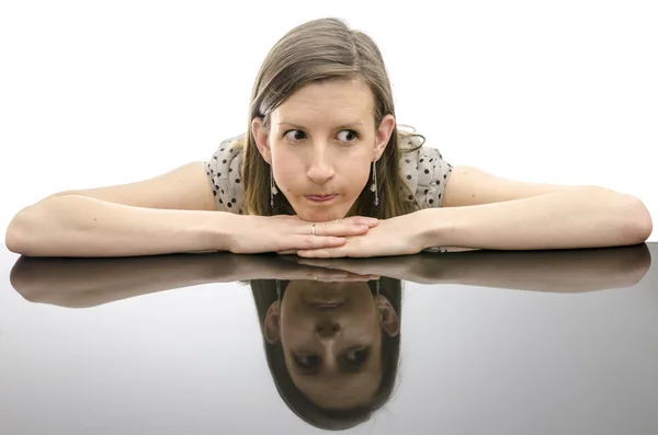 Mulher preocupada apoiando-se em uma mesa — Fotografia de Stock