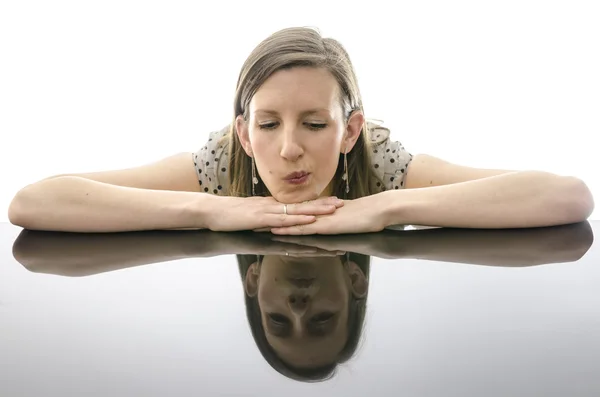 Portret van een peinzende jonge vrouw leunend op een tabel — Stockfoto