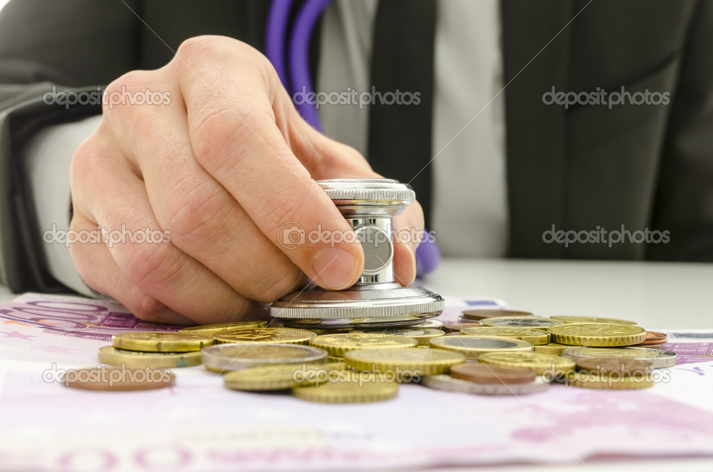 Businessman holding stethoscope over European currency