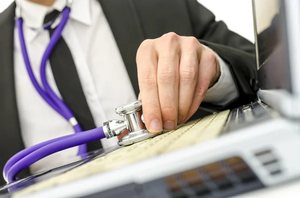 Närbild på reparatör håller stetoskop av laptop tangentbord — Stockfoto