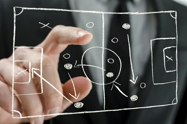 Coach pointing to a football strategy plan — Stock Photo, Image