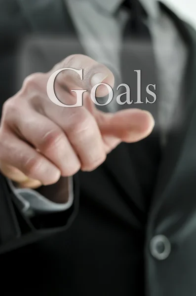 Male hand pointing at Goals icon on a touch screen interface — Stock Photo, Image