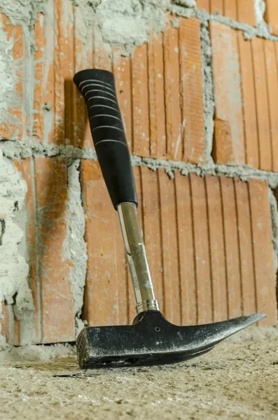 Hammer leaning on brick wall — Stock Photo, Image