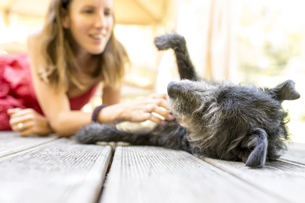 Young woman petting her dog — Stock Photo, Image