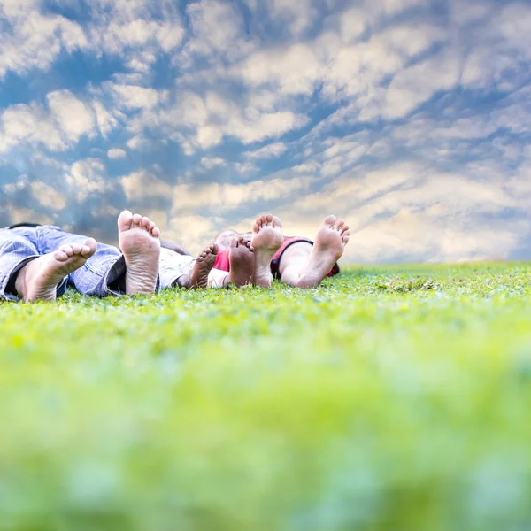 Familie liggen in gras — Stockfoto