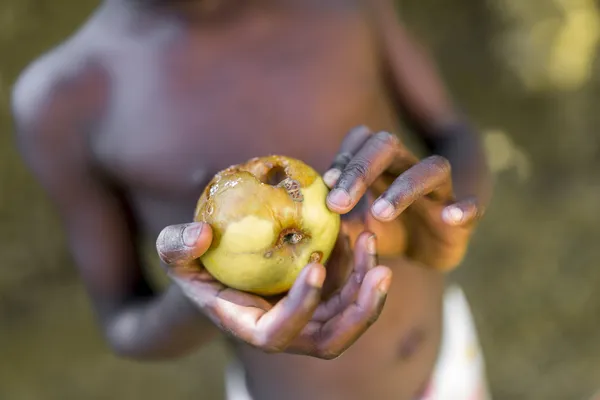 Criança negra segurando maçã podre — Fotografia de Stock