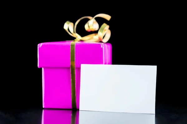 Розовый завернутый подарок с пустой картой — стоковое фото