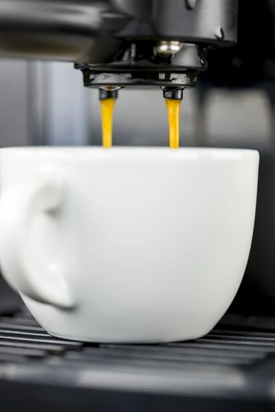 Espresso derramando em uma xícara — Fotografia de Stock
