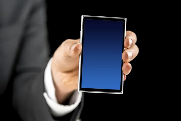Бизнесмен держит мобильный телефон с голубым пустым экраном — стоковое фото