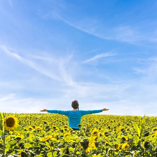 Donna in piedi nel campo dei girasoli — Foto Stock