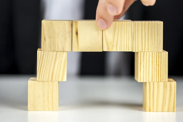 Making a bridge of wooden cubes — Stock Photo, Image