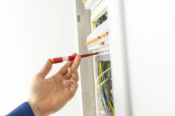 Electricista probando una placa de circuito eléctrico — Foto de Stock