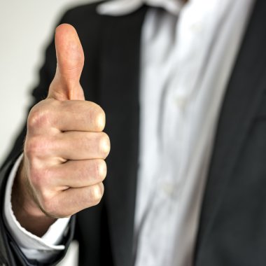 Baş parmağı havada bir iş adamı.