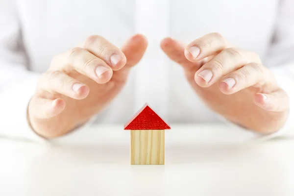 Mannelijke handen die betrekking hebben op en de bescherming van een huis — Stockfoto