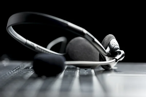 Headset lying on a laptop computer keyboardHeadset lying on a la — Stock Photo, Image