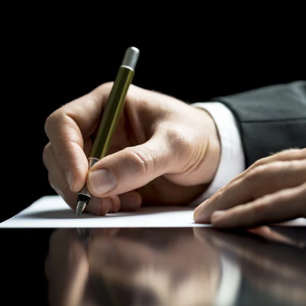 Empresario escribiendo en una hoja de papel blanco — Foto de Stock