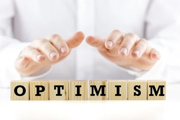 Man shielding the word Optimism with his hands — Stock Photo, Image