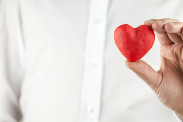 Hombre sosteniendo un romántico corazón rojo — Foto de Stock