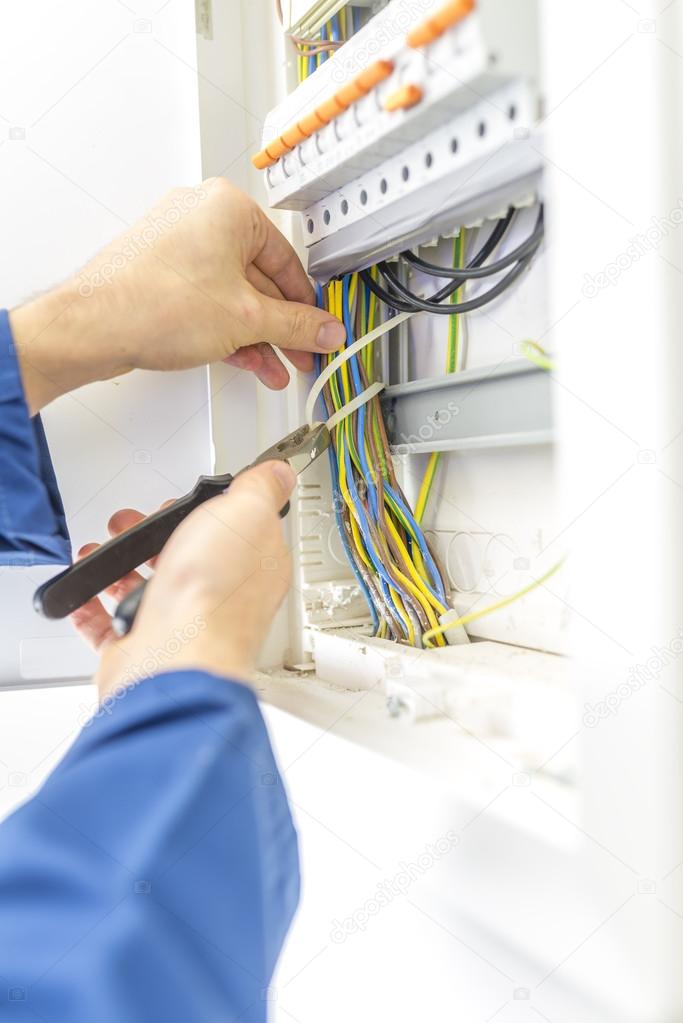 Electrician checking the wiring in a fuse box