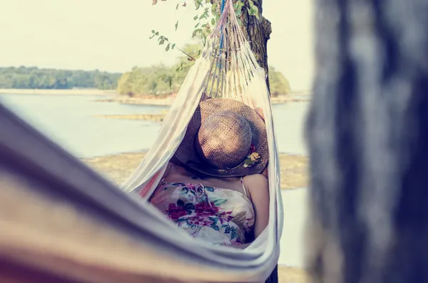 Frau entspannt sich in einer Hängematte am Meer — Stockfoto