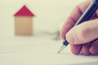 Man signing a deed of sale on a house clipart